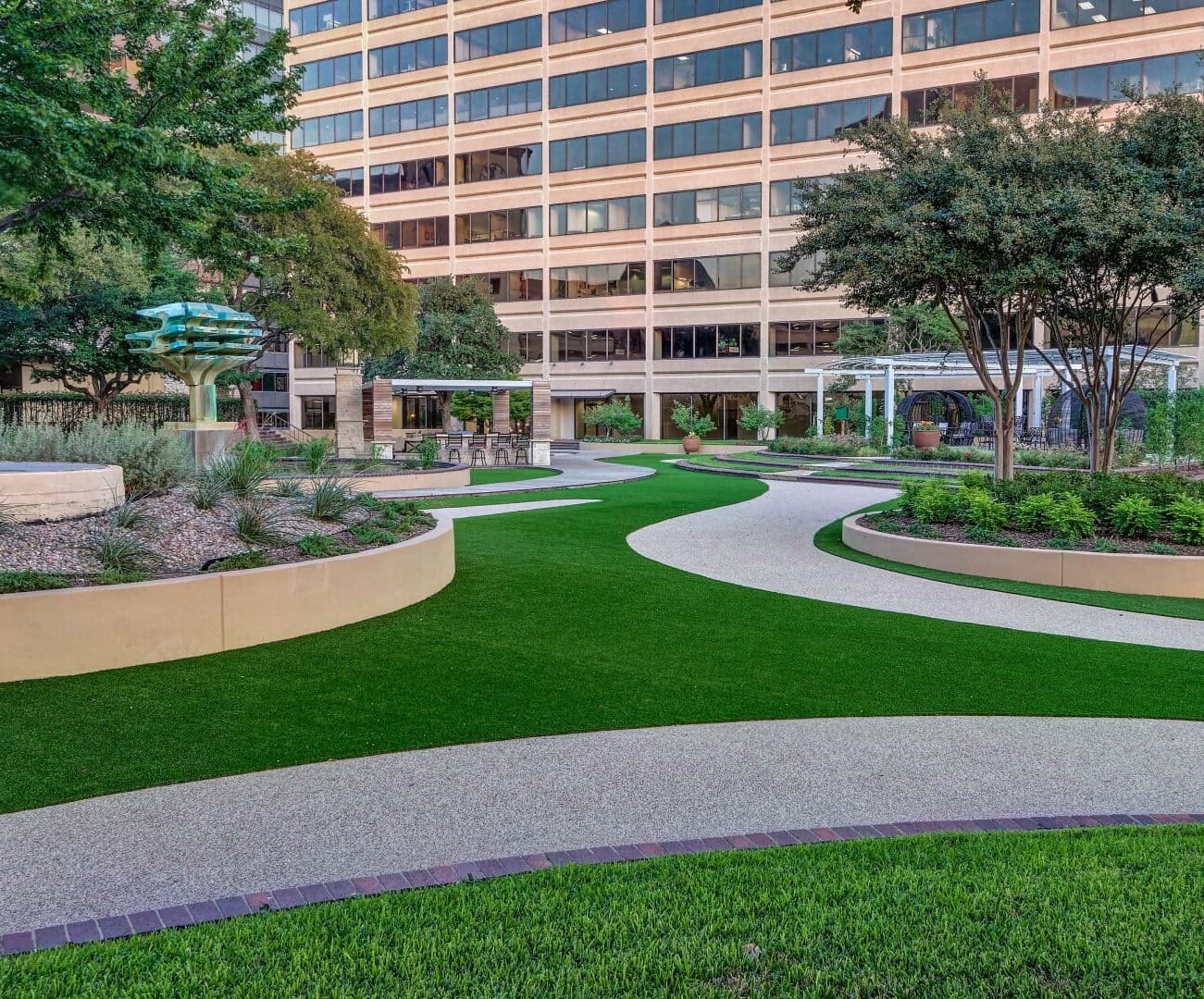 a walkway with landscaping in front of a commercial building